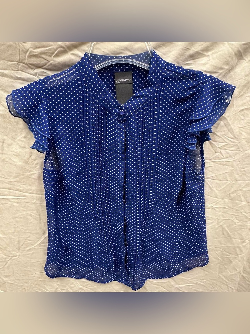 Covington blue polka dot button up blouse with ruffles.